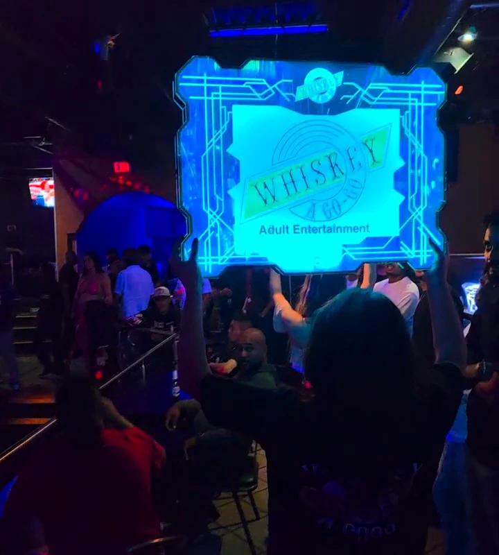 The illuminated Whiskey sign carried through the club